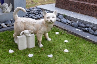 Grave of a cat, stone cat statue in the pet cemetery, RIP