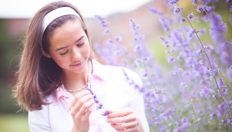 Portrait of teenage girl by purple catmint