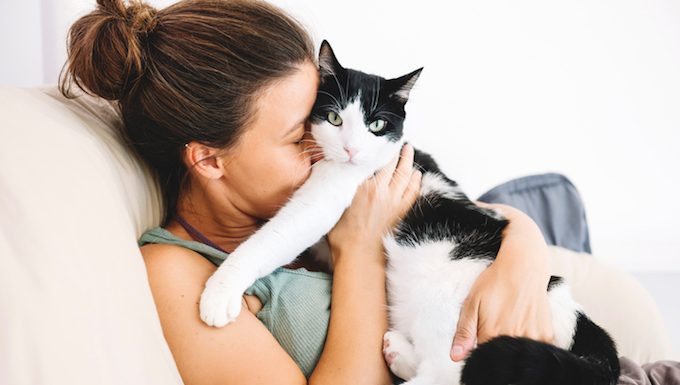 woman hugging cat