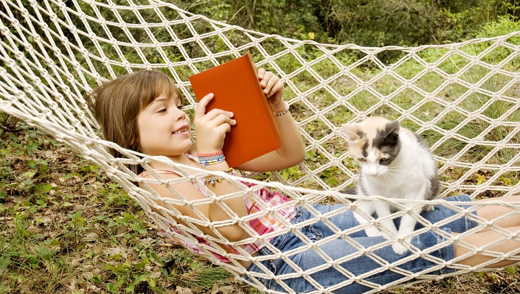 Seven years old reading in a hammock with her cat on her lap.More atBest friends Lightbox: