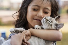 little girl snuggling cat teaching children to be gentle with cats