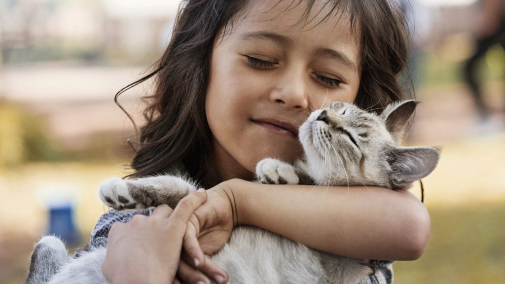 little girl snuggling cat teaching children to be gentle with cats